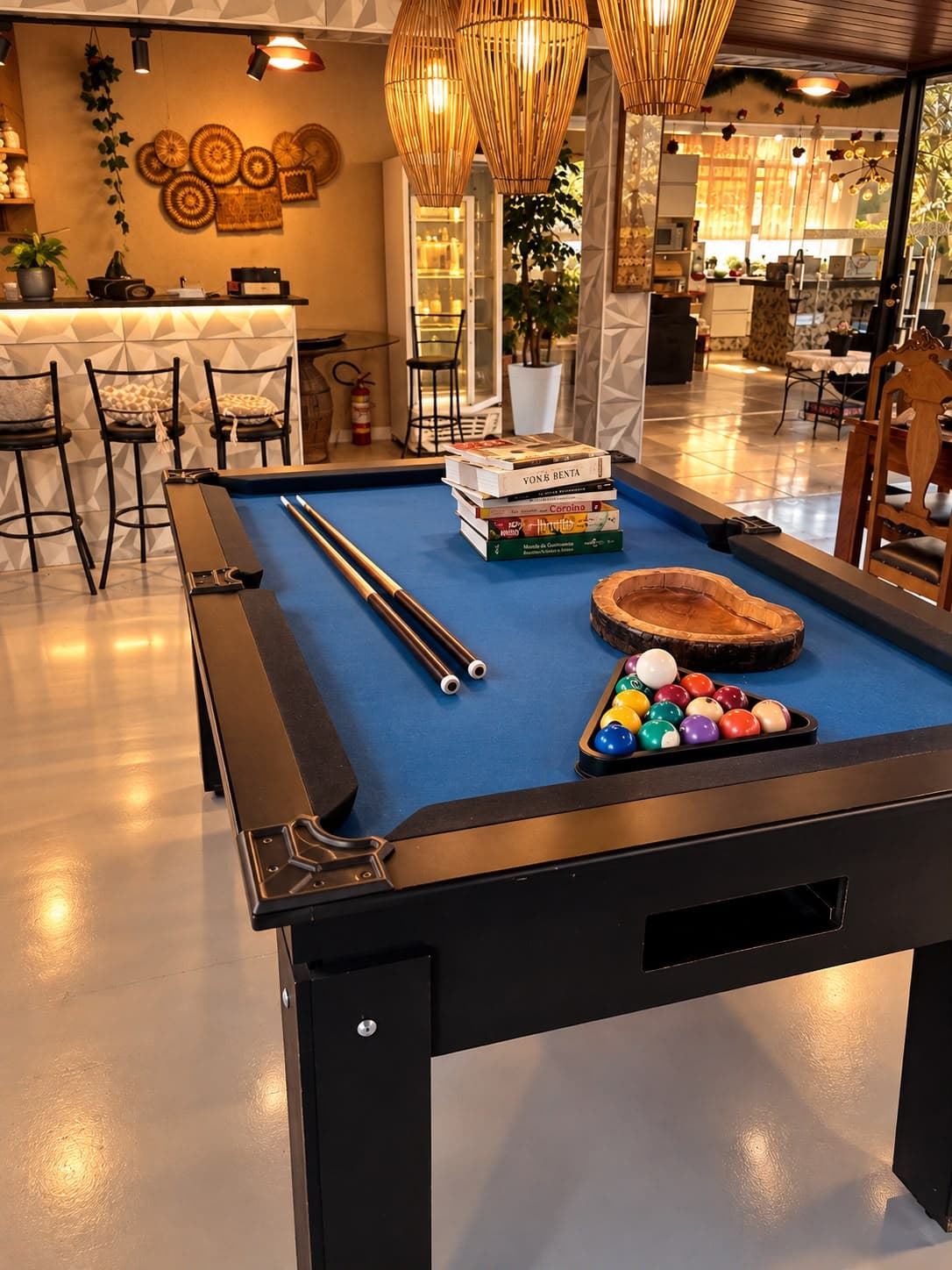Mesa de bilhar com bar ao fundo