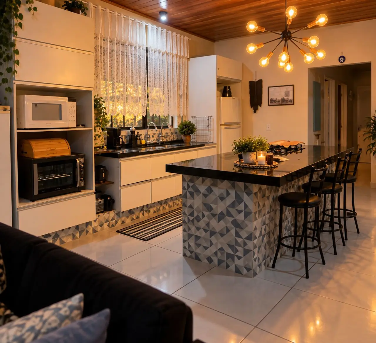 Cozinha equipada com armários brancos, bancada de granito e banquetas